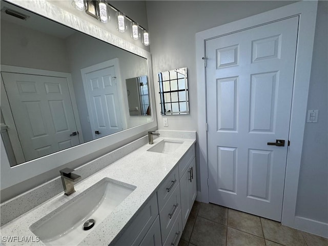 full bathroom with double vanity, tile patterned flooring, visible vents, and a sink