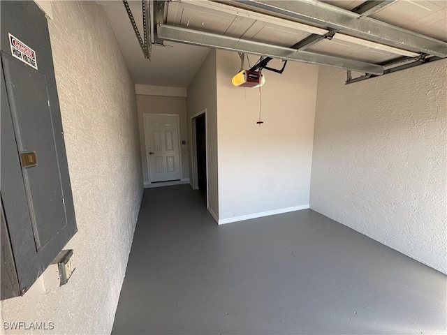 garage featuring baseboards, a textured wall, electric panel, and a garage door opener