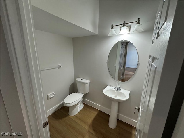 bathroom featuring wood finished floors, toilet, and baseboards