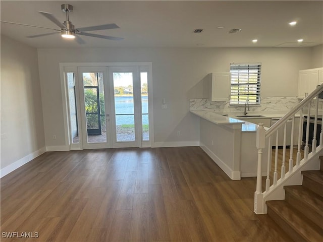 interior space featuring recessed lighting, a sink, baseboards, stairs, and dark wood finished floors