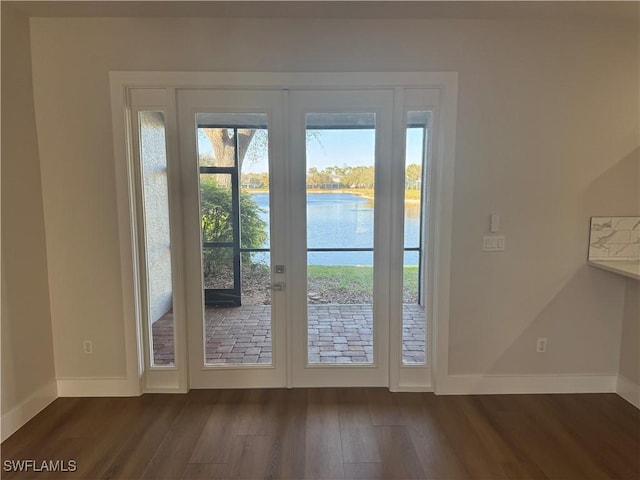 doorway to outside featuring french doors, a water view, dark wood finished floors, and baseboards