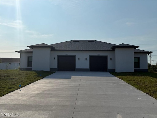 prairie-style house with a garage, a front yard, driveway, and stucco siding