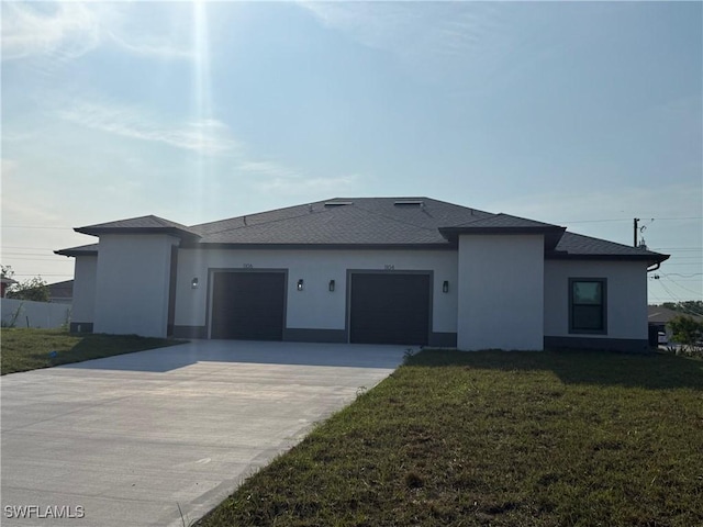 view of front facade featuring a garage, driveway, a front lawn, and stucco siding