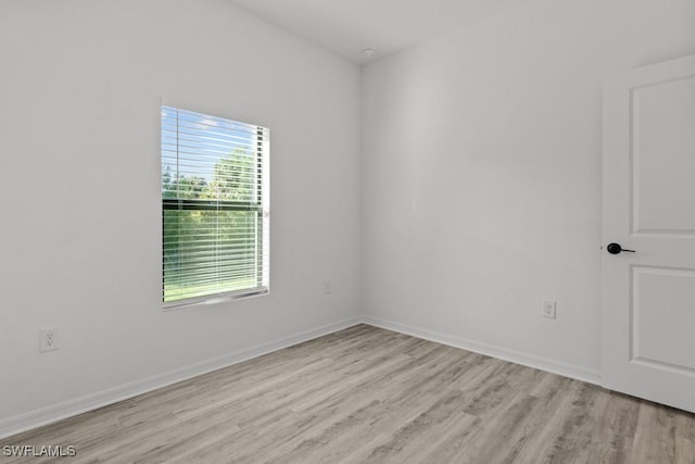 spare room with light wood-style flooring and baseboards