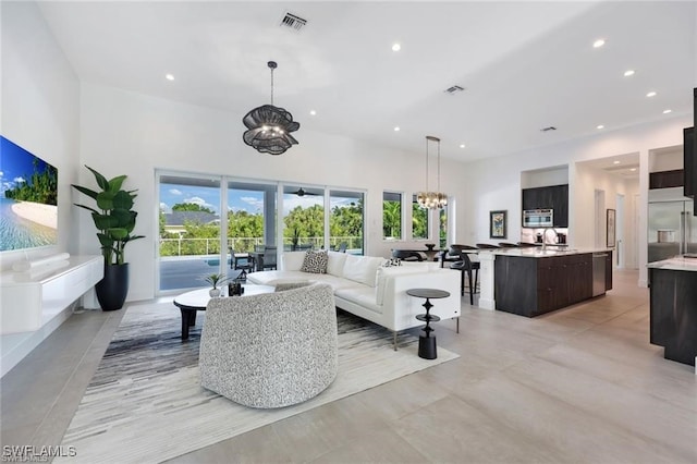 living area with recessed lighting, a wealth of natural light, and an inviting chandelier