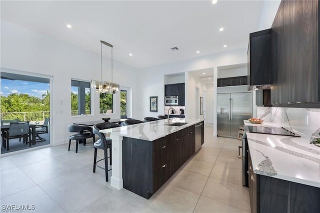 kitchen with decorative light fixtures, a spacious island, appliances with stainless steel finishes, a sink, and modern cabinets