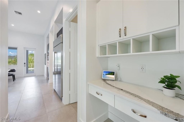 hallway with recessed lighting, light tile patterned flooring, visible vents, and baseboards