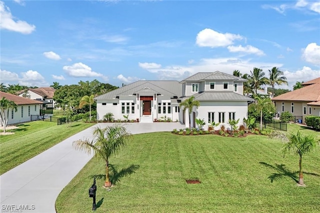 view of front facade featuring metal roof, a front lawn, a standing seam roof, and fence