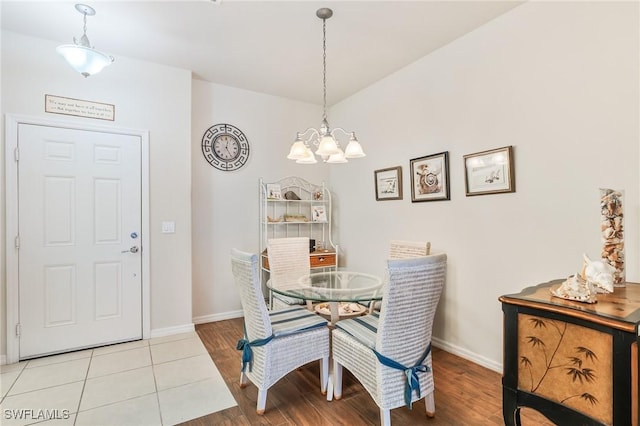 dining space featuring an inviting chandelier, light wood-style flooring, and baseboards