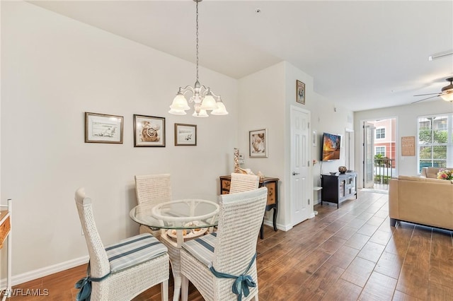 dining room with dark wood finished floors, baseboards, and ceiling fan with notable chandelier