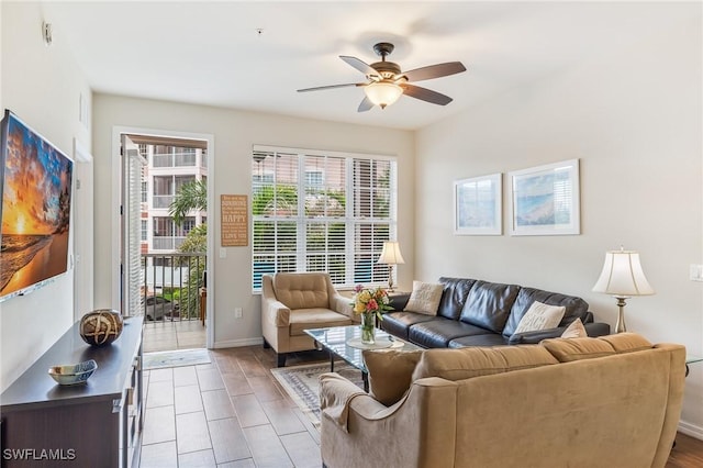 living area featuring a ceiling fan and baseboards