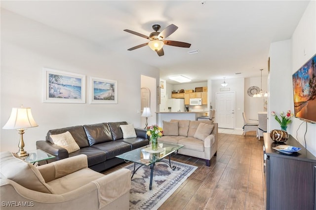 living area featuring dark wood-style floors, ceiling fan, and visible vents