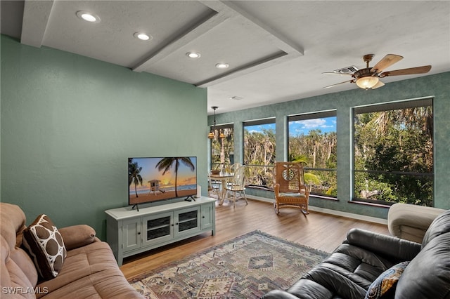 living area with light wood finished floors, recessed lighting, visible vents, a textured wall, and ceiling fan with notable chandelier