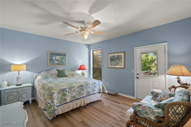 bedroom featuring a ceiling fan, baseboards, and wood finished floors