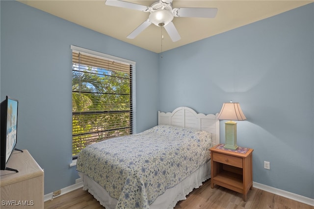 bedroom featuring ceiling fan, baseboards, and wood finished floors