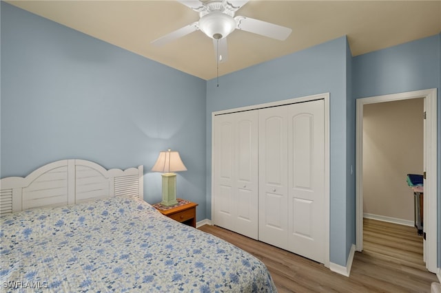 bedroom featuring ceiling fan, a closet, wood finished floors, and baseboards