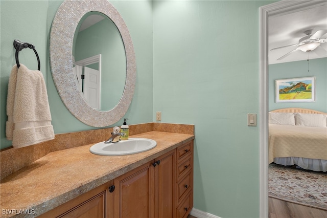 bathroom with a ceiling fan, wood finished floors, vanity, and ensuite bathroom