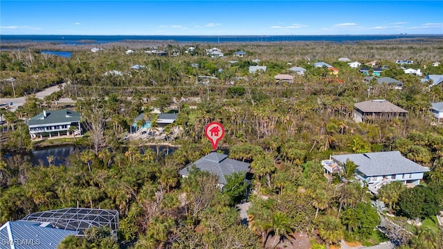 drone / aerial view with a water view and a wooded view