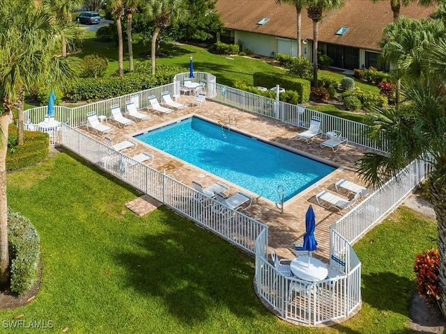 pool featuring a patio, a yard, and fence