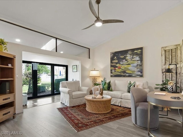 living room with high vaulted ceiling, ceiling fan, and light wood finished floors