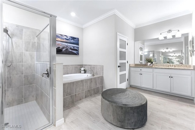 full bath with ornamental molding, a garden tub, vanity, and a shower stall