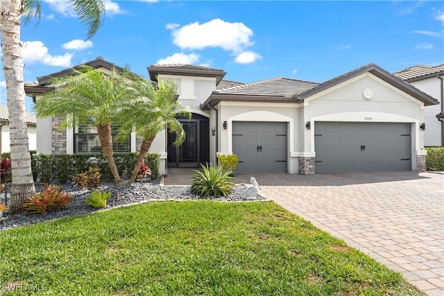 view of front of home with a garage, stone siding, decorative driveway, and stucco siding