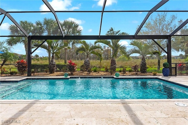 outdoor pool featuring glass enclosure and a patio