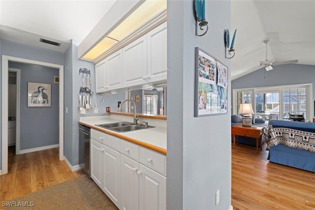 kitchen featuring dishwasher, light wood-type flooring, a sink, and white cabinets