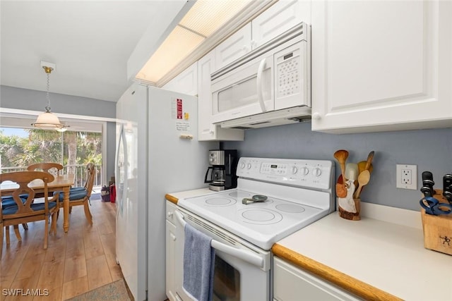 kitchen featuring pendant lighting, light countertops, white appliances, and white cabinets