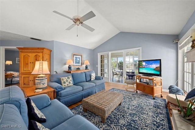 living area with a healthy amount of sunlight, visible vents, vaulted ceiling, and wood finished floors