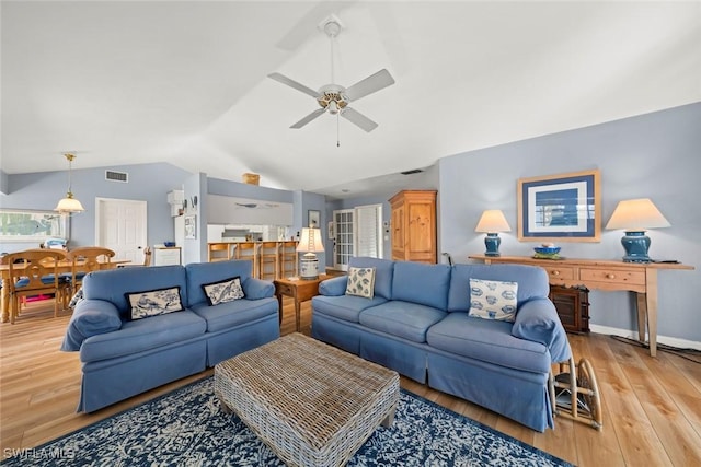 living area with lofted ceiling, light wood-style flooring, visible vents, and ceiling fan