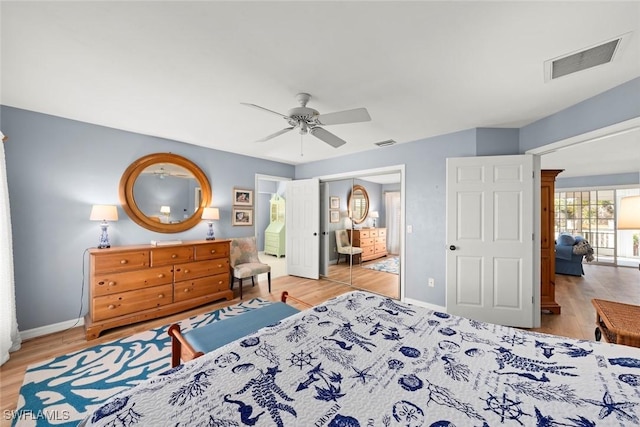 bedroom featuring baseboards, visible vents, and wood finished floors