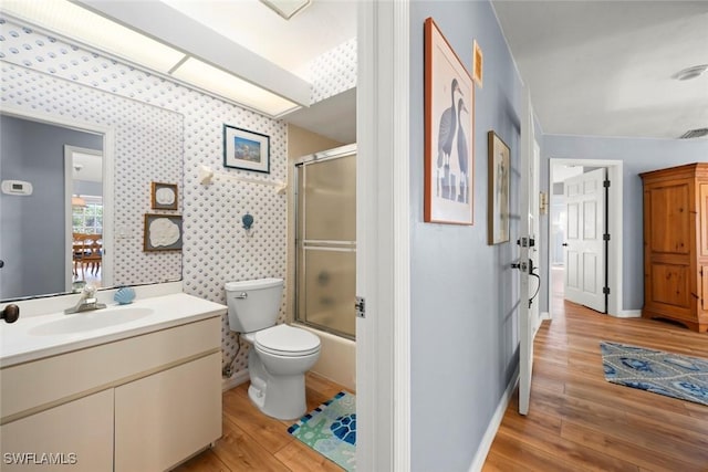 full bath with wallpapered walls, baseboards, toilet, wood finished floors, and vanity