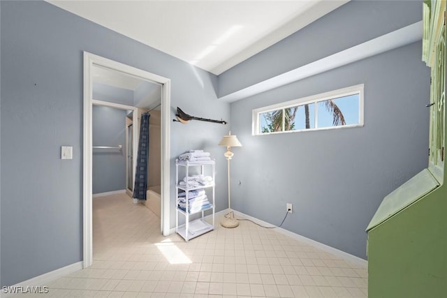 unfurnished bedroom with baseboards and tile patterned floors