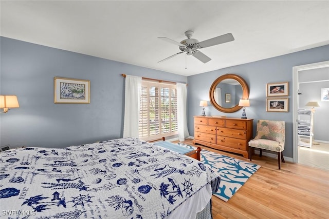 bedroom with wood finished floors, a ceiling fan, and baseboards