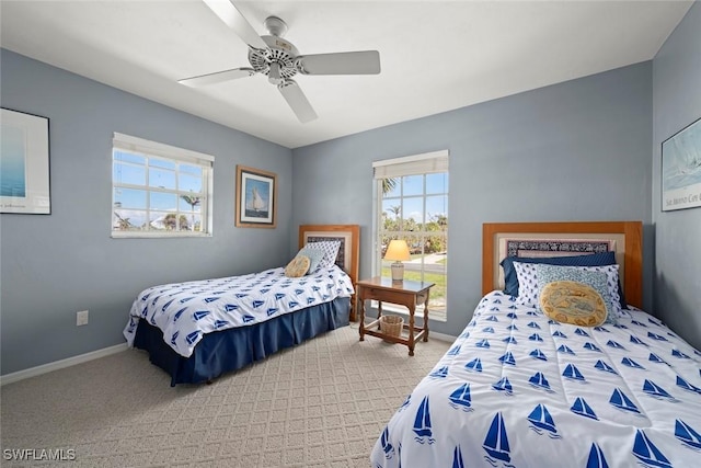 carpeted bedroom with ceiling fan and baseboards