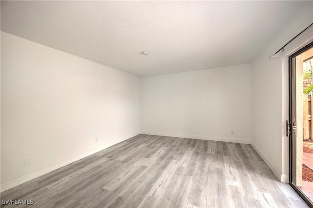 empty room featuring light wood-style flooring and baseboards