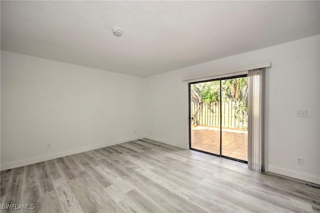 spare room with light wood-style floors and baseboards