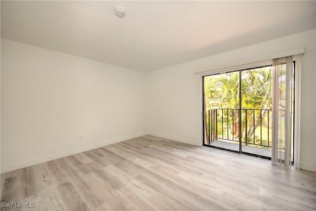 unfurnished room with baseboards and light wood-style floors