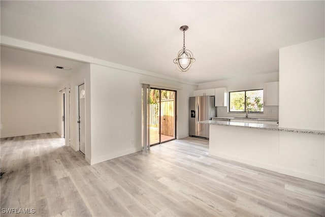 interior space featuring light wood-style floors, visible vents, and baseboards