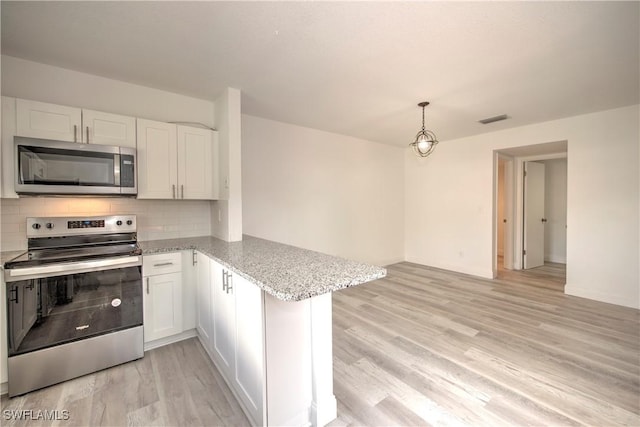 kitchen featuring stainless steel appliances, visible vents, white cabinets, and a peninsula