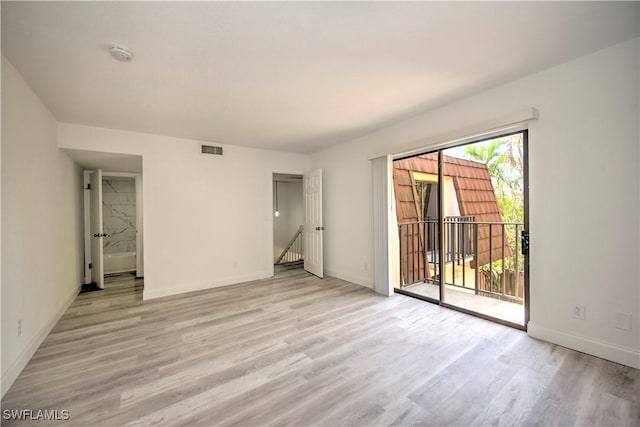 unfurnished room featuring light wood-style flooring, visible vents, and baseboards