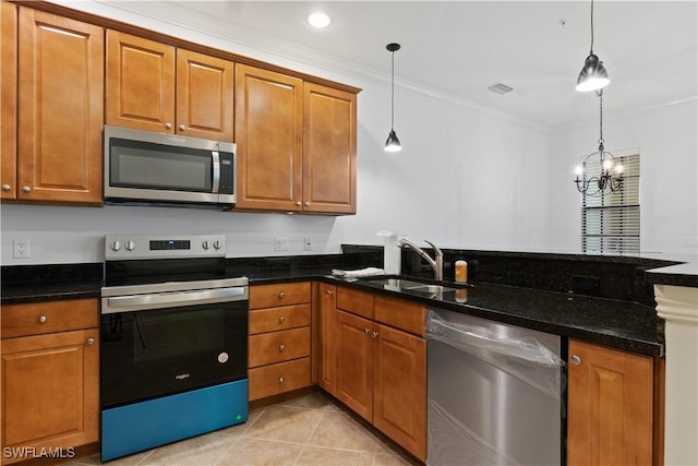 kitchen with stainless steel appliances, brown cabinets, a sink, and pendant lighting