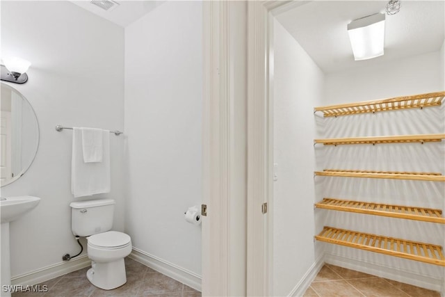 bathroom with visible vents, tile patterned flooring, toilet, and baseboards