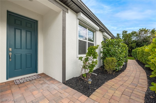 view of exterior entry featuring stucco siding