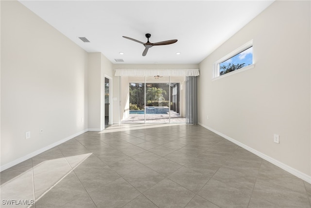 empty room with visible vents, ceiling fan, baseboards, and light tile patterned floors