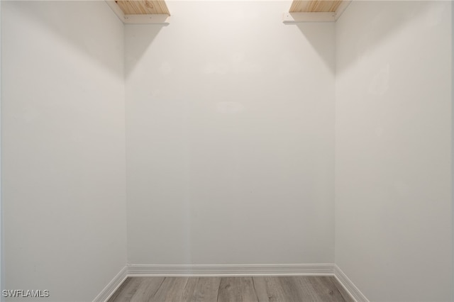 walk in closet with wood finished floors