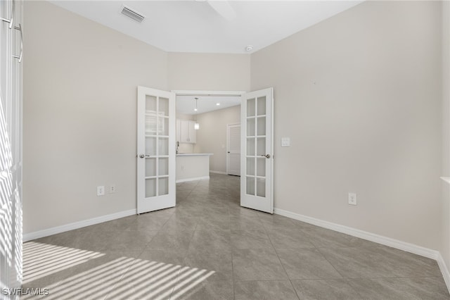 empty room with french doors, visible vents, baseboards, and light tile patterned floors