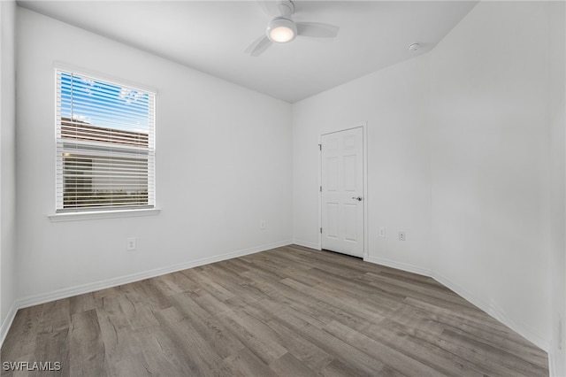 empty room featuring a ceiling fan, light wood-style flooring, and baseboards