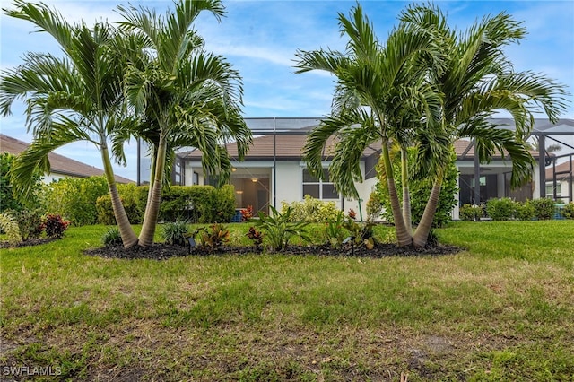 view of front facade featuring a front lawn, a lanai, and stucco siding